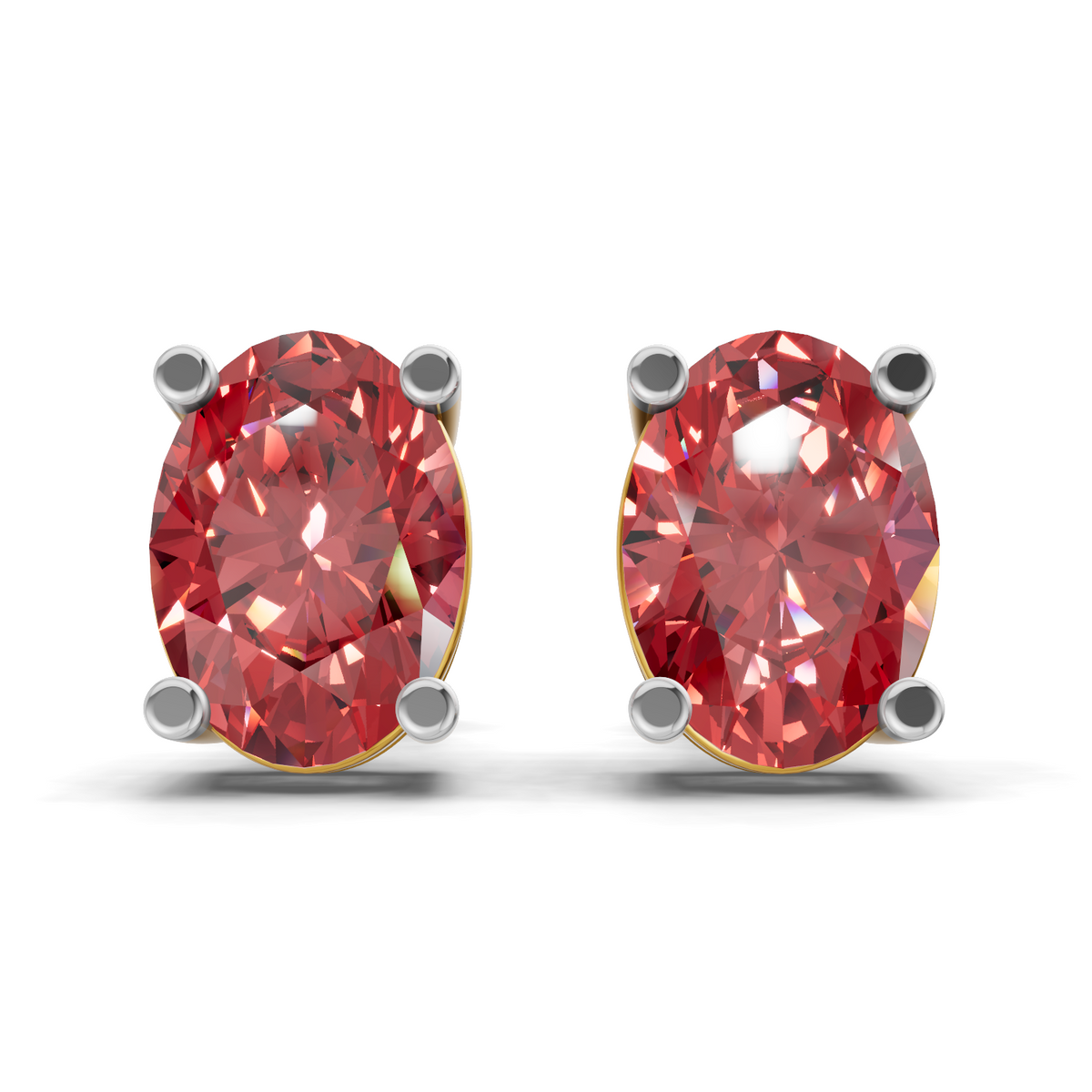 A pair of oval-cut red gemstone stud earrings in four-prong settings with gold and silver metal borders, shown on a clean white background.