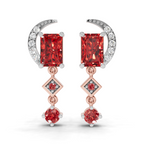 A pair of rose gold and white gold drop earrings featuring rectangular red gemstones, a crescent moon with small clear stones, and diamond-shaped accents on a white background.