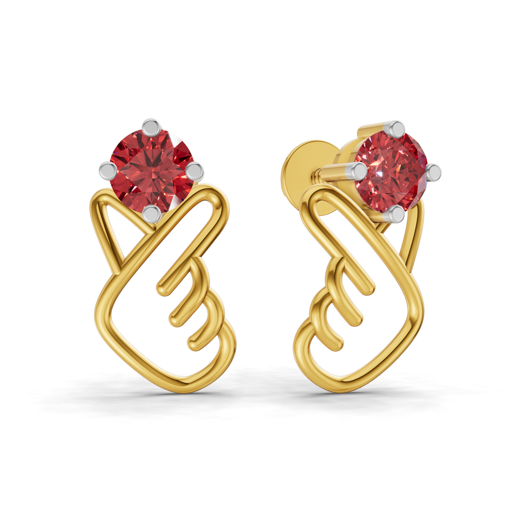 A pair of gold huggie stud earrings featuring a red gemstone at the top, set with small silver-colored accent prongs, shown on a plain white background.