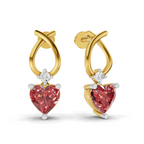 A pair of gold huggie hoop earrings with a dangling heart-shaped pink gemstone and a small clear round stone above it, shown on a white background.